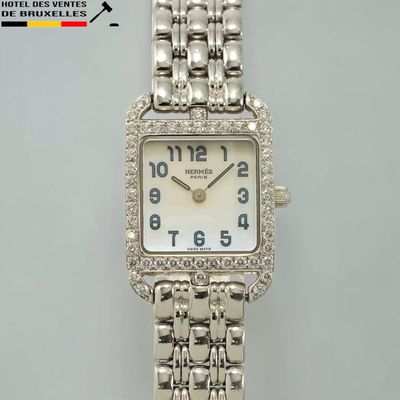 une montre en argent avec un cadran blanc et des diamants