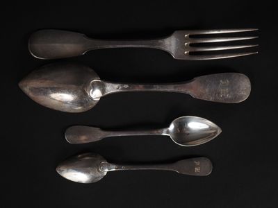 trois cuillères en argent et deux cuillères en argent sur un fond noir