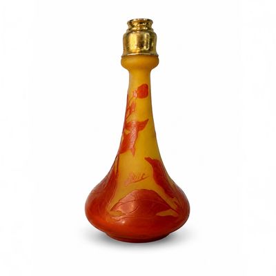 une bouteille en verre rouge et jaune avec un bouchon doré