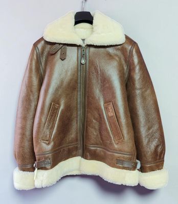une veste en cuir marron suspendue à un cintre accroché au mur