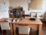 une table en bois avec deux chaises et un bureau sur lequel se trouve une imprimante