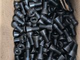 a cardboard box full of black screws and nuts