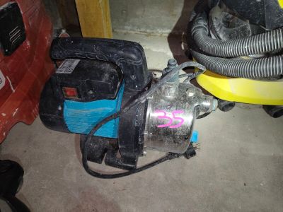 a small blower sitting on the floor next to a red car