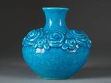 a blue vase with flowers on it sitting on a table