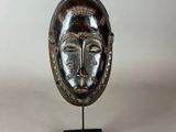 a close up of a sculpture of a face with a bird on top of it