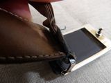 a hand that is holding a cell phone in a wallet