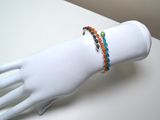two bracelets on a mannequin hand on a white table