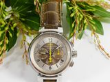 the watch is sitting on the table next to the flowers