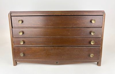 a wooden chest of drawers with brass knobs on each drawer