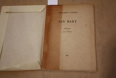 un livre ouvert sur une table, avec une feuille de papier à l'intérieur