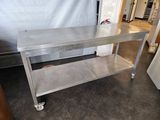 a stainless steel table on wheels in a room