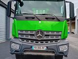 un camion vert garé devant un immeuble