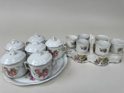 une assiette sur laquelle sont posées des tasses et des soucoupes, à côté d'un plateau sur lequel sont posées des tasses et des soucoupes