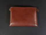 a brown leather pouch on a black surface