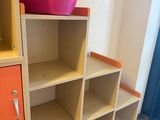 a shelf with a pink bowl on top of it in a room