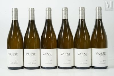 six bouteilles de vin blanc sont alignées sur une table
