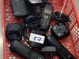 de nombreux téléphones portables dans un panier rouge posé par terre