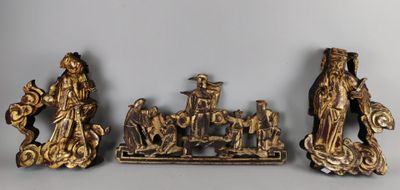 trois figurines en or représentant des personnes et des animaux, posées sur une table