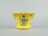 an image of a yellow vase with blue flowers on it