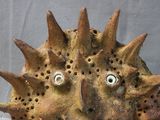a clay sculpture of a face with spikes on it