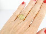a woman ' s hand with a red manicure holding a gold coin