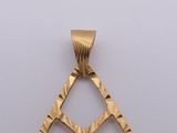 an image of a gold pendant with a diamond cut design