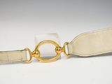 beige leather belt with a gold ring and a white leather strap
