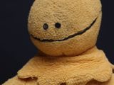 a stuffed animal that is wearing a yellow jacket