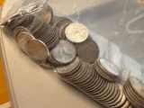 a bag of coins sitting on a table next to a pile of coins