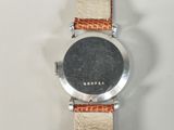 a close up of a watch on a white surface