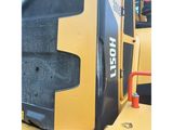 the back end of a yellow and black bulldozer sitting on top of a pile of dirt