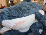 un grand requin en peluche posé par terre