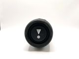 a small black object on the table next to a bottle of wine