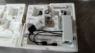 a white box with a microscope and other items in it