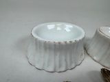 a white bowl and a silver spoon sitting on a table