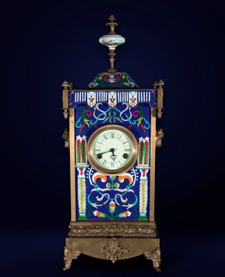 an ornate clock with a blue background and a white clock on top of it
