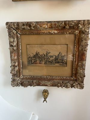 two framed pictures hanging on the wall above a toilet