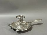 an antique silver plated candle holder on a gray background