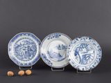 trois assiettes bleues et blanches ornées de motifs et des noix