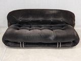 a black couch that is sitting on a white floor