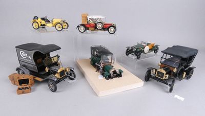 cinq modèles réduits de voitures exposés dans une vitrine