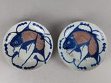 deux assiettes bleues et blanches ornées de motifs de poissons, posées sur une table