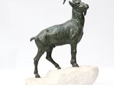 statue of a ram on a rock on a white background