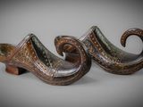 pair of wooden clogs with a curved design on them