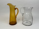 two glass pitchers sitting next to each other on a table
