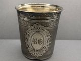 une vieille coupe en argent ornée d'un monogramme, posée sur une table