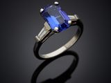 a blue sapphire and diamond ring on a black surface
