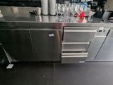 un plan de travail en inox sur lequel sont posés plusieurs verres à vin