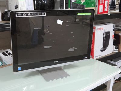un écran d'ordinateur posé sur un bureau blanc