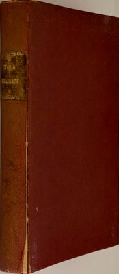 an old book sitting on top of a white table next to a clock
